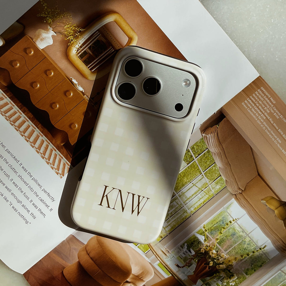 Phone case with 'KNW' initials on a magazine next to a box