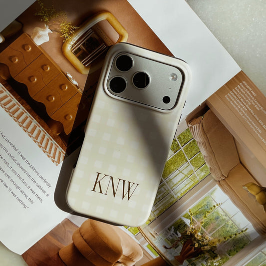 Phone case with 'KNW' initials on a magazine next to a box